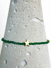 Lade das Bild in den Galerie-Viewer, Zierliches Armband aus facettiertem, dunkelgrünem Diopsid mit Stern und Blümchen aus vergoldetem Echtsilber, Detailansicht auf Betonkegel