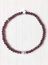 Lade das Bild in den Galerie-Viewer, Klassisch-dezentes Armband aus facettiertem rotem Granat und einem mattierten Stern aus Echtsilber, begleitet von einem zierlichen Silberblümchen, verschlusslos auf Silikonband aufgezogen.
