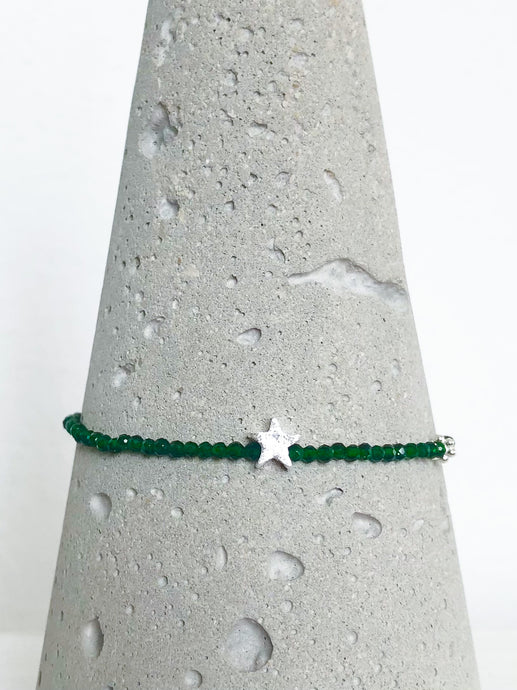 Zierliches Armband aus facettiertem, dunkelgrünem Diopsid mit Stern und Blümchen aus Echtsilber, Detailansicht auf Betonkegel