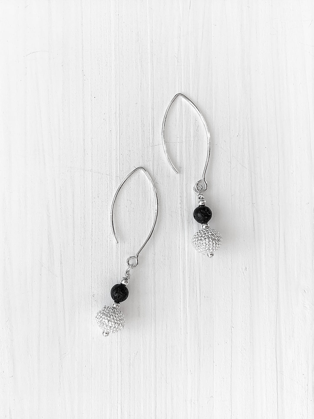 Handgemachte Ohrhänger von Svenja Scharwächter aus schwarzer Lava und einer diamantierten Zierkugel an einer Brisur aus Echtsilber online kaufen.