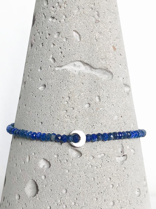 Armband aus facettierten Lapislazuli-Perlen mit Mond und diamantierter Kugel aus Sterlingsilber - Detailansicht auf Betonkegel.